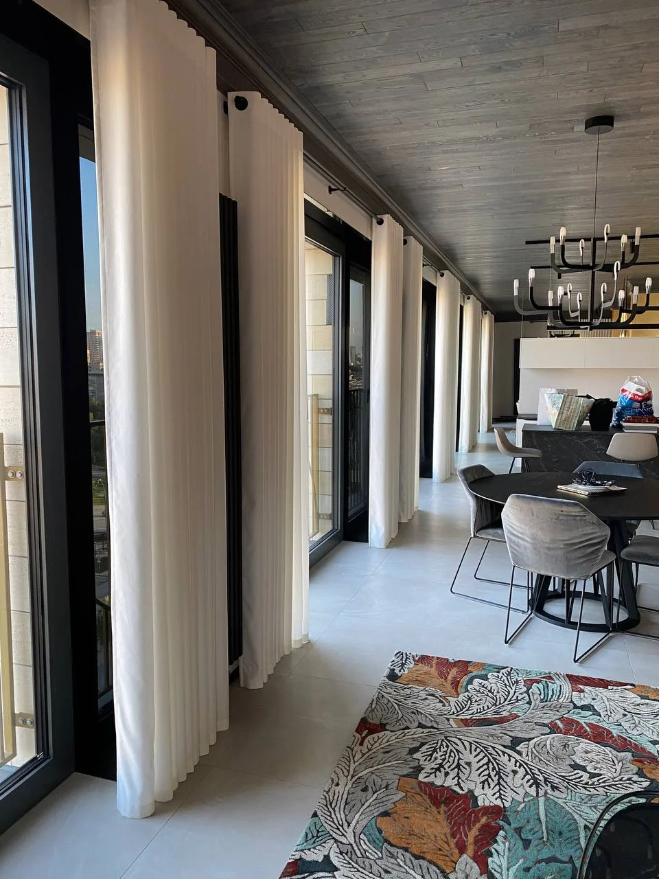 Панорама гостиной — шторы, обеденный стол, люстра